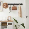An entryway with a wall-mounted coat rack holding accessories, a cabinet below, and a plant. Produktbild-Vorschau