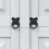 A close-up view of two black ring handles on a white wooden cabinet. Voir les images du produit