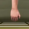 A hand resting on a green textured surface, possibly a cushion or fabric. Produktbild-Vorschau