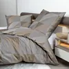 A close-up view of a bed with geometric patterned bedding. Produktbild-Vorschau