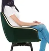 A woman sitting in a green chair. Voir les images du produit