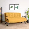 A yellow sofa is shown in a room with two framed pictures of leaves on the wall and a plant in a pot. Náhled obrázku produktu