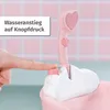 A close-up of a pink toy bathtub with a hand pressing a button on the side, and a heart-shaped showerhead. Produktbild-Vorschau