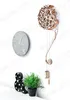 A wall with two clocks, a decorative ampersand light, and a small potted plant. Voir les images du produit