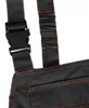 A close-up view of the straps and pocket of a pair of black overalls with orange stitching. Produktbild-Vorschau