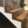 A close-up view of a modern wooden staircase with glass railings. Anteprima dell’immagine prodotto