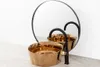 A modern bathroom sink and faucet setup with a round mirror in the background. Produktbild-Vorschau