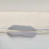 A close-up view of a mattress protector with gray handles. Produktbild-Vorschau