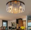A modern interior with a dining table and chairs, a fireplace, and a kitchen area. A ceiling light fixture is prominently displayed. Produktbild-Vorschau