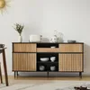 A sideboard cabinet with wooden doors and drawers, decorated with kitchen appliances and bowls.