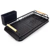 A black dish rack with wooden handles sits on a black tray next to a black utensil holder. The dish rack has slots for plates and cups and a section for cutlery. The background is pure white. Podgląd zdjęcia produktu