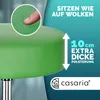 Close-up of a green stool with text overlays highlighting its features and a logo. Produktbild-Vorschau
