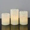 Three LED candles of varying heights are arranged on a dark surface against a light gray background. Produktbild-Vorschau
