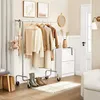A hallway or entryway scene with a clothing rack, a shoe cabinet, and decor. Produktbild-Vorschau