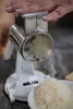 A person is using a hand grater to grate cheese into a bowl. Produktbild-Vorschau