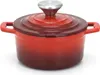 A red cast iron pot with a silver lid and handle is shown against a white background. Anteprima dell’immagine prodotto
