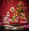 A festive Christmas scene with ornaments, gifts, and cookies, featuring a decorated Christmas tree in the background. Produktbild-Vorschau