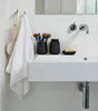 A close-up view of a bathroom sink with various accessories. Produktbild-Vorschau