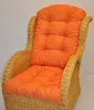 A close-up shot of an orange cushion on a wicker chair. Produktbild-Vorschau