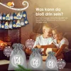 Two children are looking at an advent calendar hanging on a string in front of a fireplace. Several small bags with numbers are hanging on the string. Three larger bags with the number 14 are in the foreground. Produktbild-Vorschau