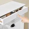 A close-up of a person's finger opening a drawer on a white cabinet. Produktbild-Vorschau