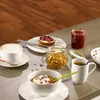 A breakfast setting with various food items and drinks on a table. Produktbild-Vorschau