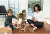 A woman and a child are playing with wooden blocks and a glue gun. Produktbild-Vorschau