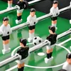 A close-up view of a foosball table with players and a ball. Náhled obrázku produktu
