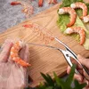 A person is using a shrimp deveiner tool to clean shrimp on a wooden cutting board. Produktbild-Vorschau