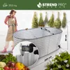 A woman stands next to a large galvanized metal raised garden bed, with bundles of dried herbs hanging above. Anteprima dell’immagine prodotto