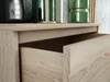 A close-up view of an open drawer on a wooden dresser. Produktbild-Vorschau