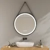A round LED mirror with a black frame hangs above a white sink on a wooden vanity. The mirror has a built-in light and touch controls. Anteprima dell’immagine prodotto