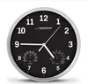 A black wall clock with a silver frame, featuring a thermometer and hygrometer. Produktbild-Vorschau