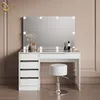 A white vanity table with a large mirror and LED lights, a stool, and some decorative items on the table. Produktbild-Vorschau