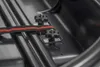 A close-up view of the interior of a black roof box, showing a red and black strap secured by two star-shaped knobs. Anteprima dell’immagine prodotto