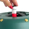 A hand is adjusting a measuring stick on a green Christmas tree stand. Náhľad obrázku produktu