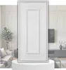A white, paneled door is displayed on a white pedestal in front of a blurred interior scene. Produktbild-Vorschau