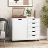 A white rolling cabinet with drawers and a door, topped with a record player and decorative items, is placed next to a sofa in a room. Anteprima dell’immagine prodotto