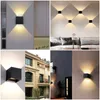 Collage of modern wall lights installed in various settings, including indoors and outdoors, showcasing their design and lighting effects. Voir les images du produit