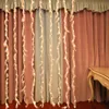A string of feather lights hanging in front of curtains, with a decorative table on the right. Produktbild-Vorschau