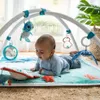 A baby is playing on a playmat with a play gym. Produktbild-Vorschau