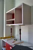 A cabinet is being installed using adjustable support poles. Anteprima dell’immagine prodotto