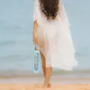 A woman walks on a beach holding a water bottle. Náhľad obrázku produktu