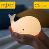 Hands holding a glowing whale-shaped night light. Produktbild-Vorschau