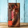A chocolate bar is placed on a wooden surface with a blue wooden background. Voir les images du produit