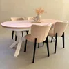 A dining table with chairs and decorative items. Voir les images du produit