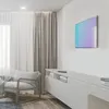 A modern living room with a TV mounted on the wall, a console table, and an armchair. Voir les images du produit