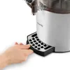 A hand is shown pulling out the drip tray of a H.Koenig hot chocolate maker. Podgląd zdjęcia produktu