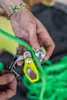 Hand hält Edelrid Ohmega Bremsassistent mit grünem Kletterseil und schwarzem Edelrid-Band Podgląd zdjęcia produktu