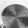 Close-up of the bottom of a stainless steel pot, showing embossed text and symbols. Podgląd zdjęcia produktu